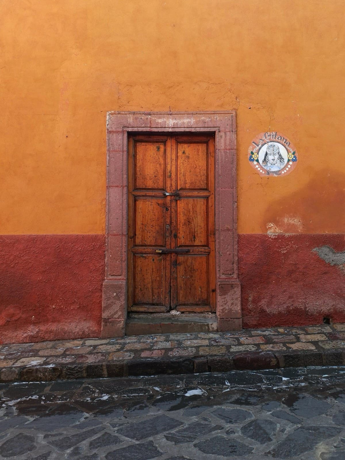 Carved wooden door set in an ochre wall