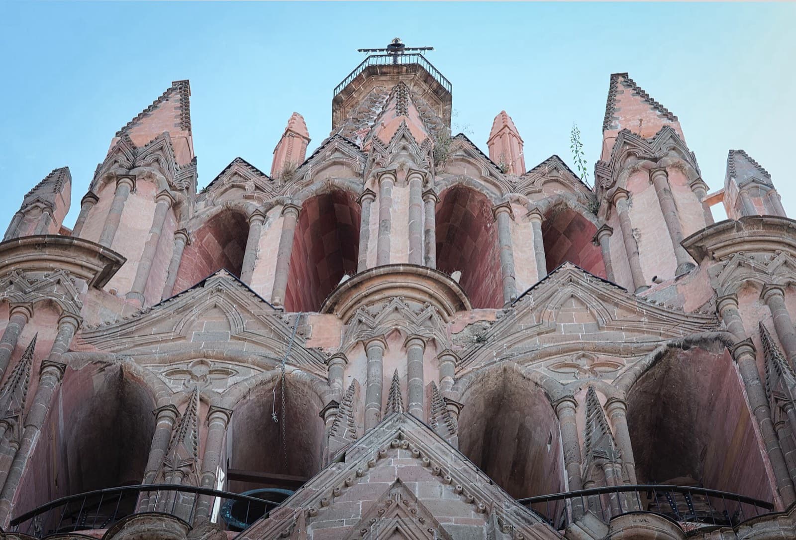 Pink sandstone spires of La Parroquia de San Miguel Arcángel at dusk